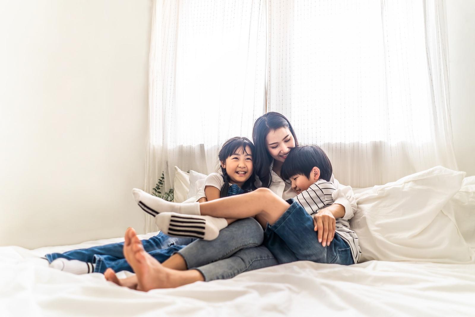 A mother at home with her children, holding them close