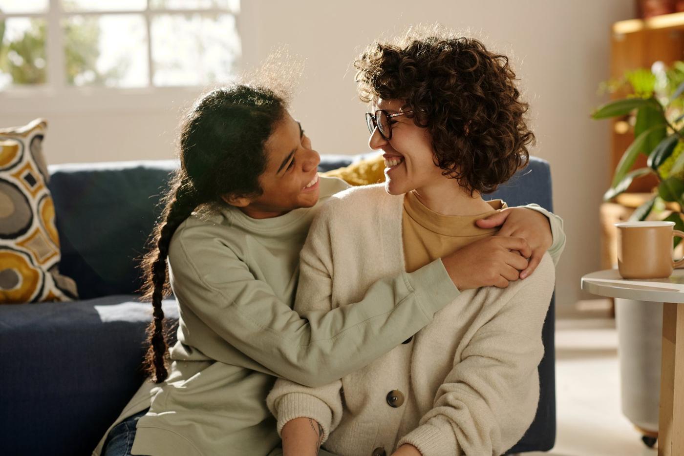 A teenager with her arms around her mother