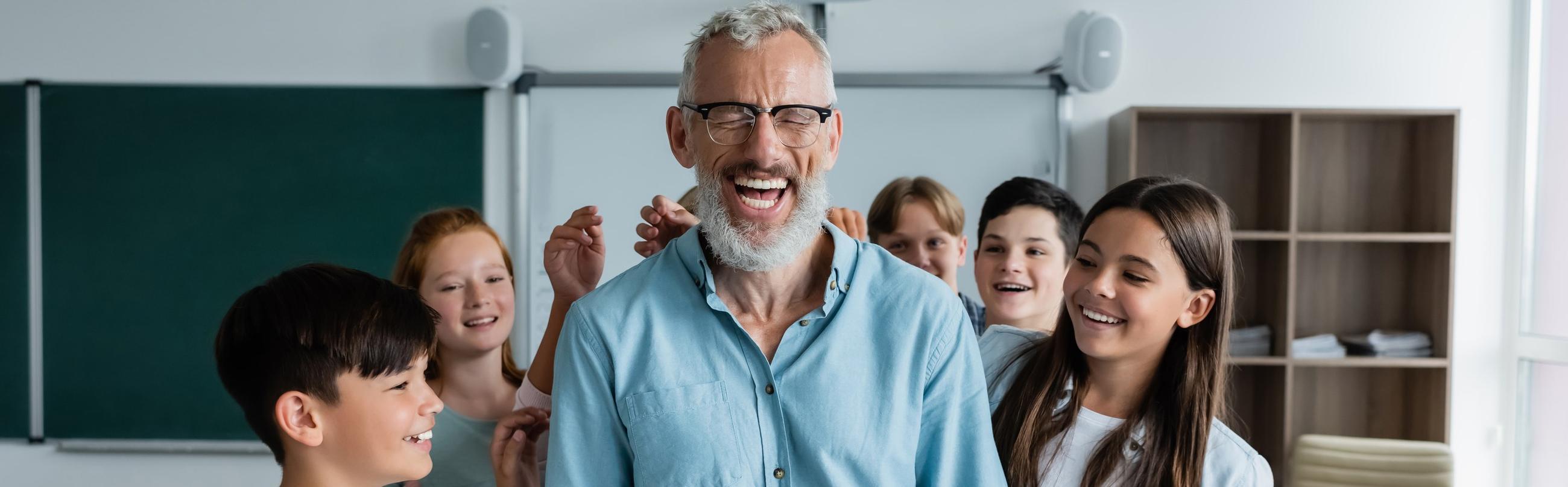 A teacher laughing with her students