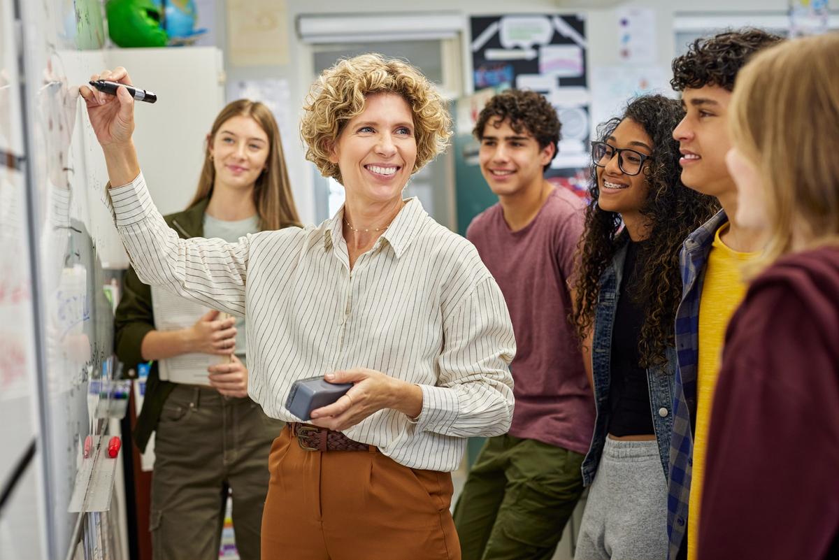 A teacher and her students at the board